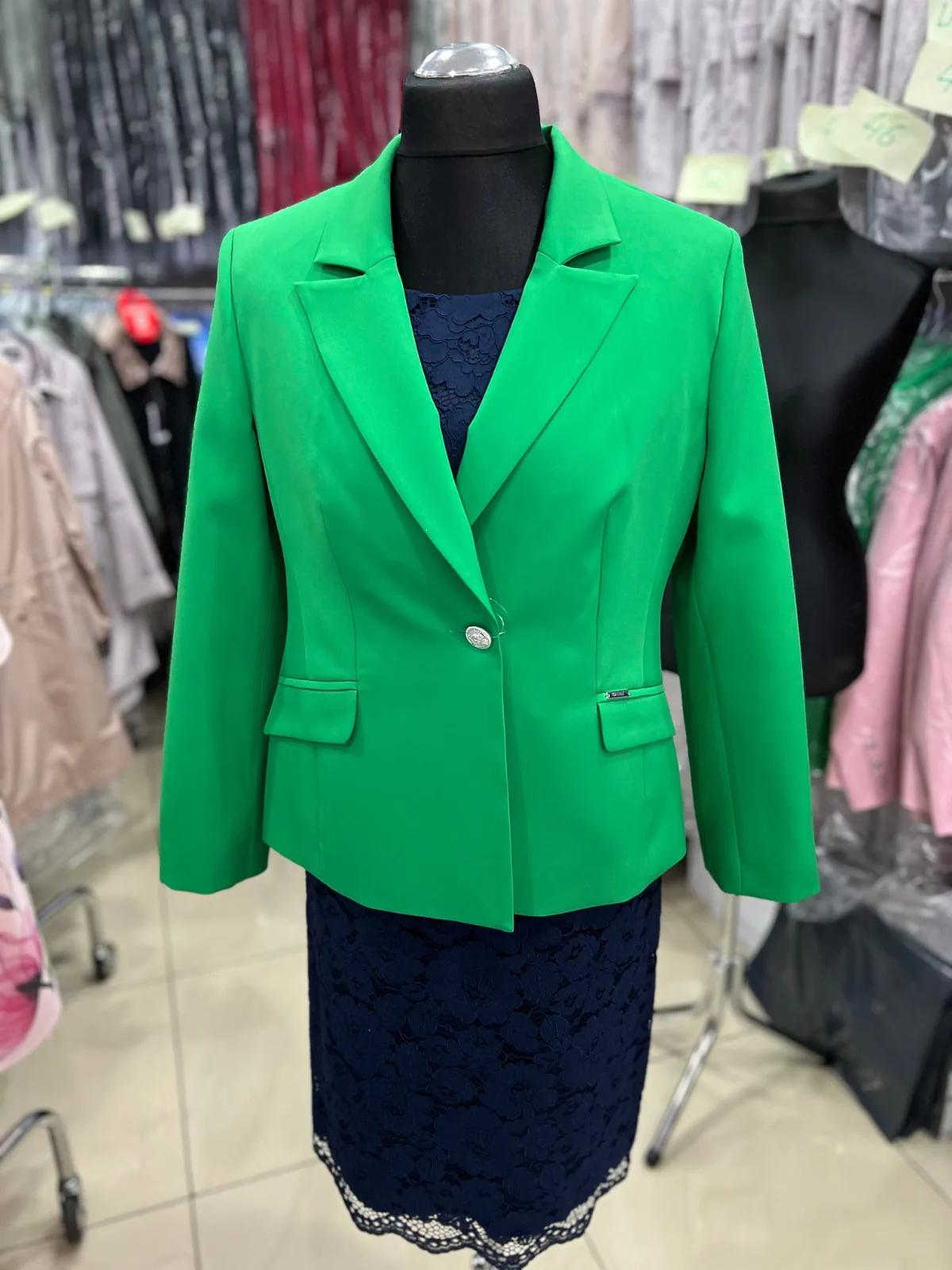 Zielona marynarka z granatowa sukienka na manekinie w sklepie stacjonarnym - srerbne guziki i dodatki